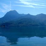 Vue estivale du lac de Savines entoure de montagnes, utilise comme environnement de pratique pour l'apnee a Serre-Poncon.